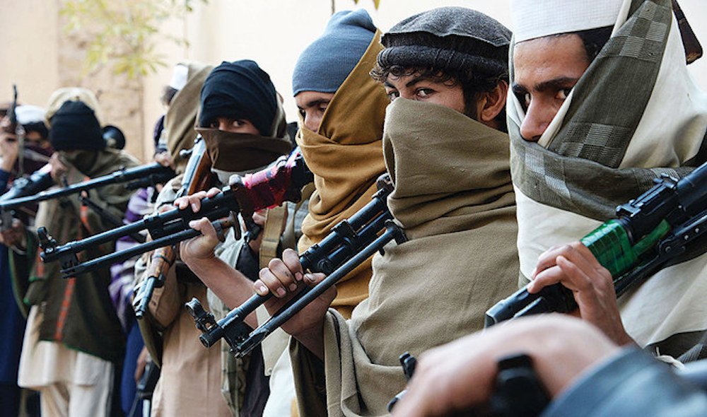 Afghan former Taliban fighters are photographed holding weapons before they hand them over as part of a government peace and reconciliation process at a ceremony in Jalalabad Feb. 8, 2015. (Taliban bomb-making snafu)