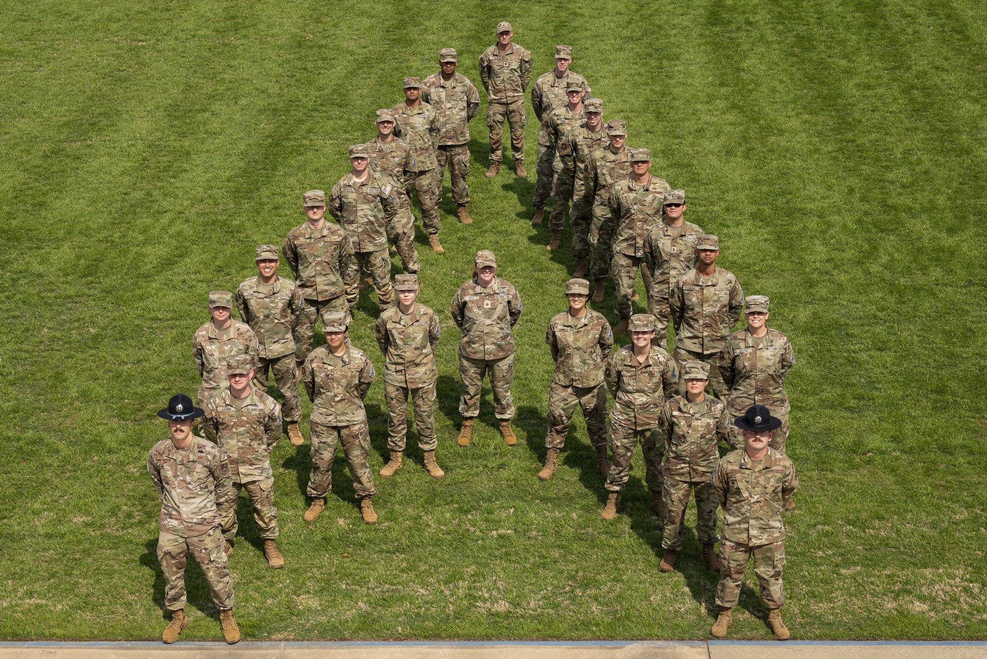 Space Force cadets and Air Force enlisted military training instructors at Officer Training School gather in a ‘delta’ formation on Welch Field, Maxwell Air Force Base.