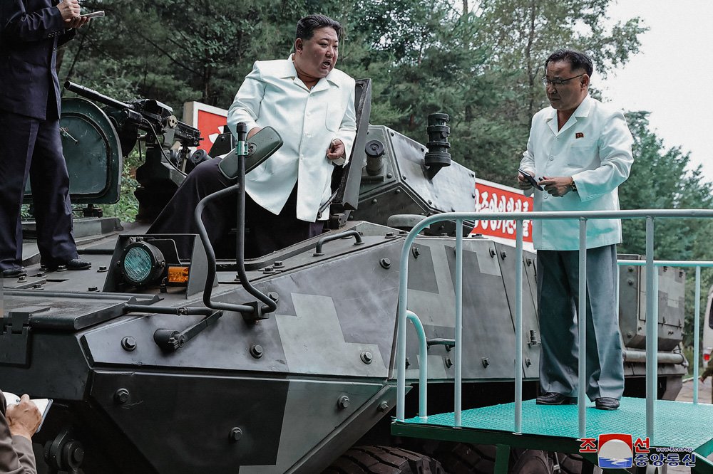 North Korean leader Kim Jong Un, center, rides on an armored vehicle.