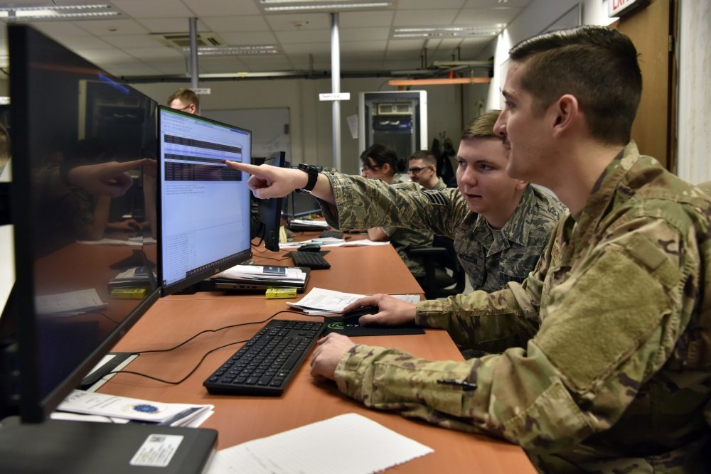 Staff Sgt. Tyler Ellingson (left), 100th Communications Squadron mission defense team supervisor, and Staff Sgt. Stephen Spor, 31st CS noncommissioned officer in charge, mission defense team, analyze information systems for potential malicious activity as part of a training scenario during exercise TACET VENARI, held at the U.S. Air Forces in Europe Regional Training Center, Ramstein Air Base, Germany, Mar. 8, 2019. U.S. Air Force photo by Master Sgt. Renae Pittman via DVIDS.