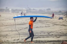 U.S. Marine carries a surfboard after surfing during the annual Commanding General’s (CG’s) Cup Surfing Competition, at the Del Mar Beach Resort on Marine Corps Base Camp Pendleton, California, June 19, 2019. The CG’s Cup is a series of competitive sporting events, which promotes combat readiness, resiliency, esprit de corps, leadership, teamwork and loyalty for active-duty Marines and Sailors through participation in sports.  (Photo by Ismael Pena)