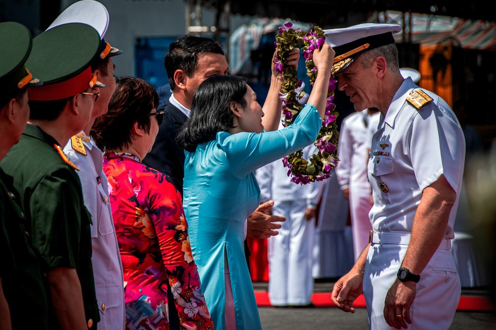 Rear Adm. Pat Hannifin, right, receives a wreath during a welcome ceremony.