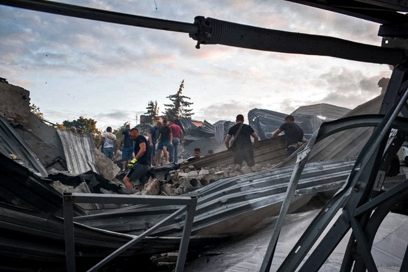 People clear the rubble in a restaurant RIA Pizza