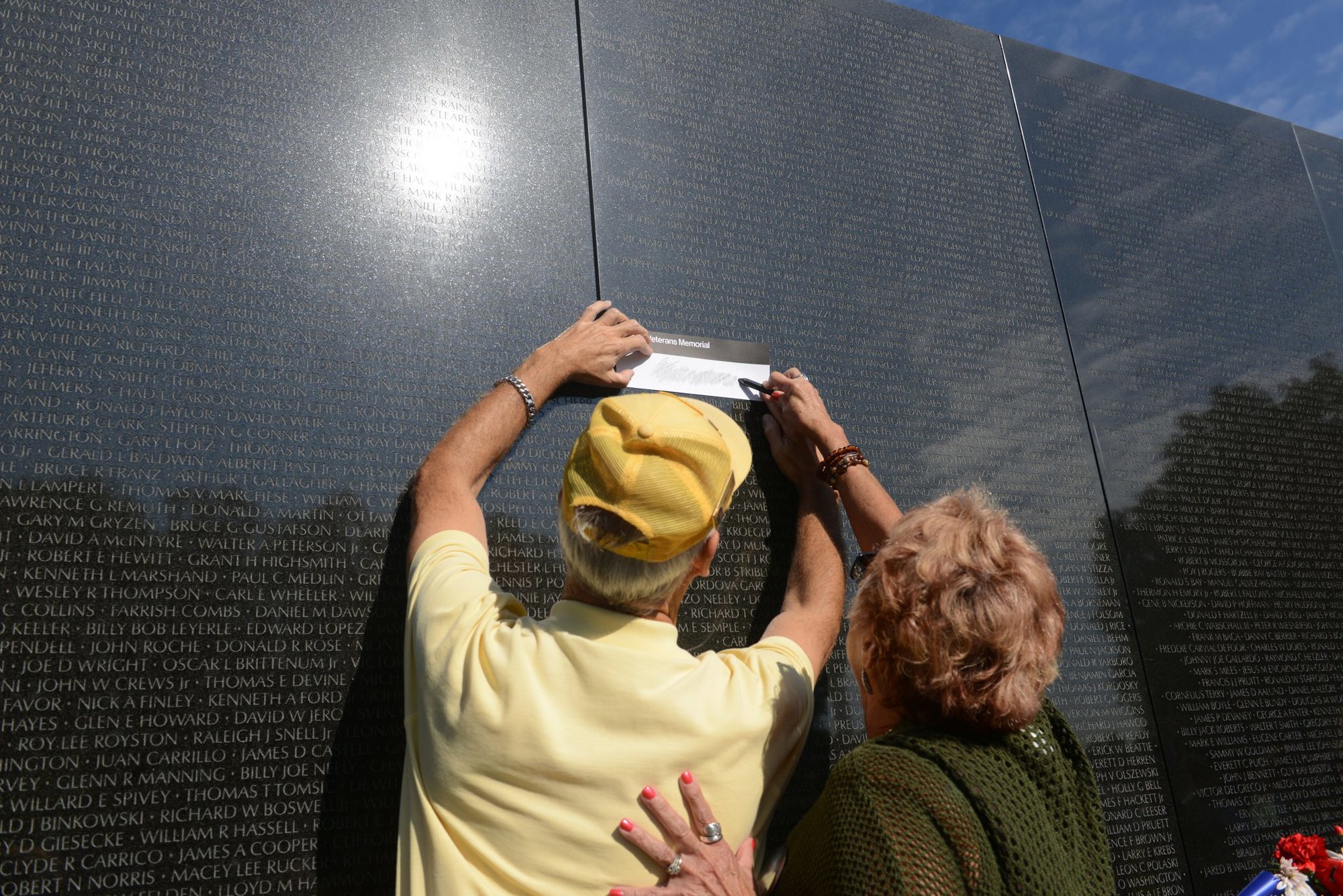 National Park Service volunteer Donald Adam helps Karen McCaslin make a rubbing of her brother’s name, Donald P. Sloat, at the Vietnam Veterans Memorial in Washington, D.C., Sept. 17, 2014. Sloat, who was an Army specialist four, was killed in action in 1970 and was awarded the Medal of Honor on Sept. 15, 2014. (Army News Service photograph by Lisa Ferdinando)