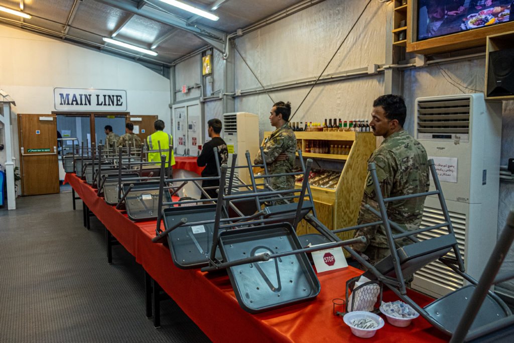 Coalition troops and contractors wait in line at a chow hall at the coalition camp at Erbil International Airport. All dining facilities on the base have gone to a takeout-only model to curb the risk of COVID-19 infections. Photo by Kevin Knodell/Coffee or Die.