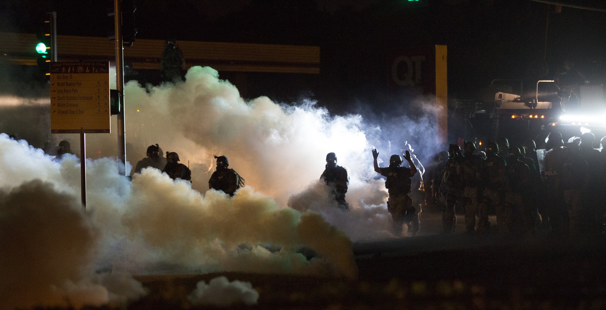 Riot police clear a street with smoke bombs while clashing with demonstrators in Ferguson, Missouri; riots in the united states