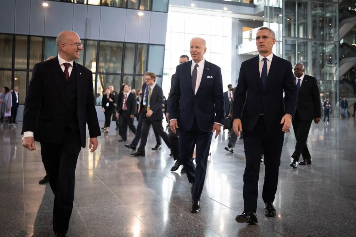 President Joe Biden and NATO Secretary General Jens Stoltenberg walk through NATO headquarters.