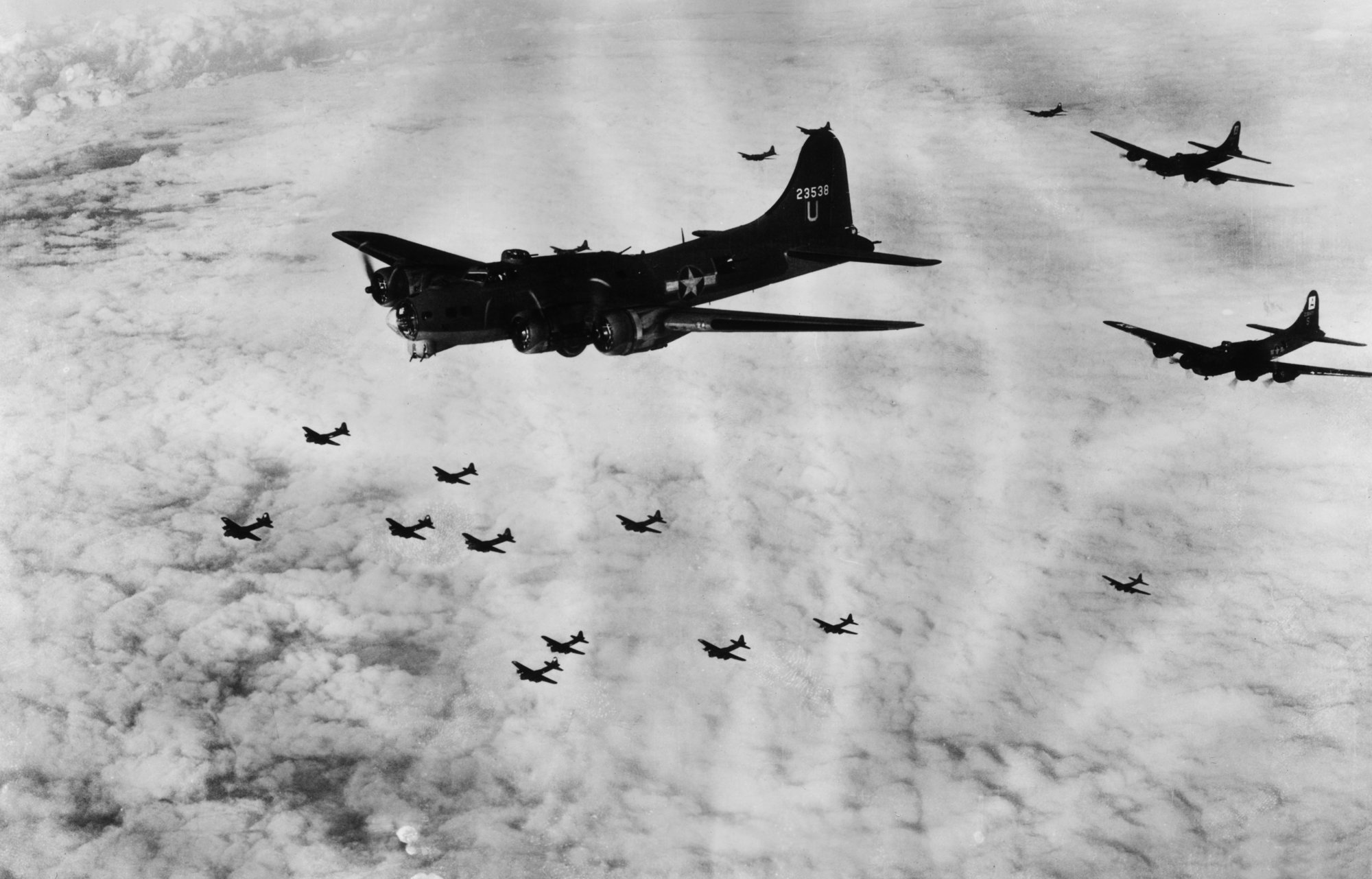 Circa 1942: A squadron of Boeing B-17Gs, known as "Flying Fortresses," flies over clouds en route to Emden, Germany, World War II. The B-17G served in every World War II combat zone and is best known for its strategic daylight bombings of German industrial targets. Photo by Hulton Archive via Getty Images.