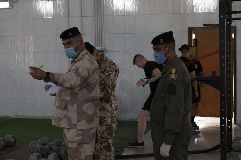 Iraqi officers survey the gym as American soldiers continue their daily exercise routine. Photo by Kevin Knodell/Coffee or Die.