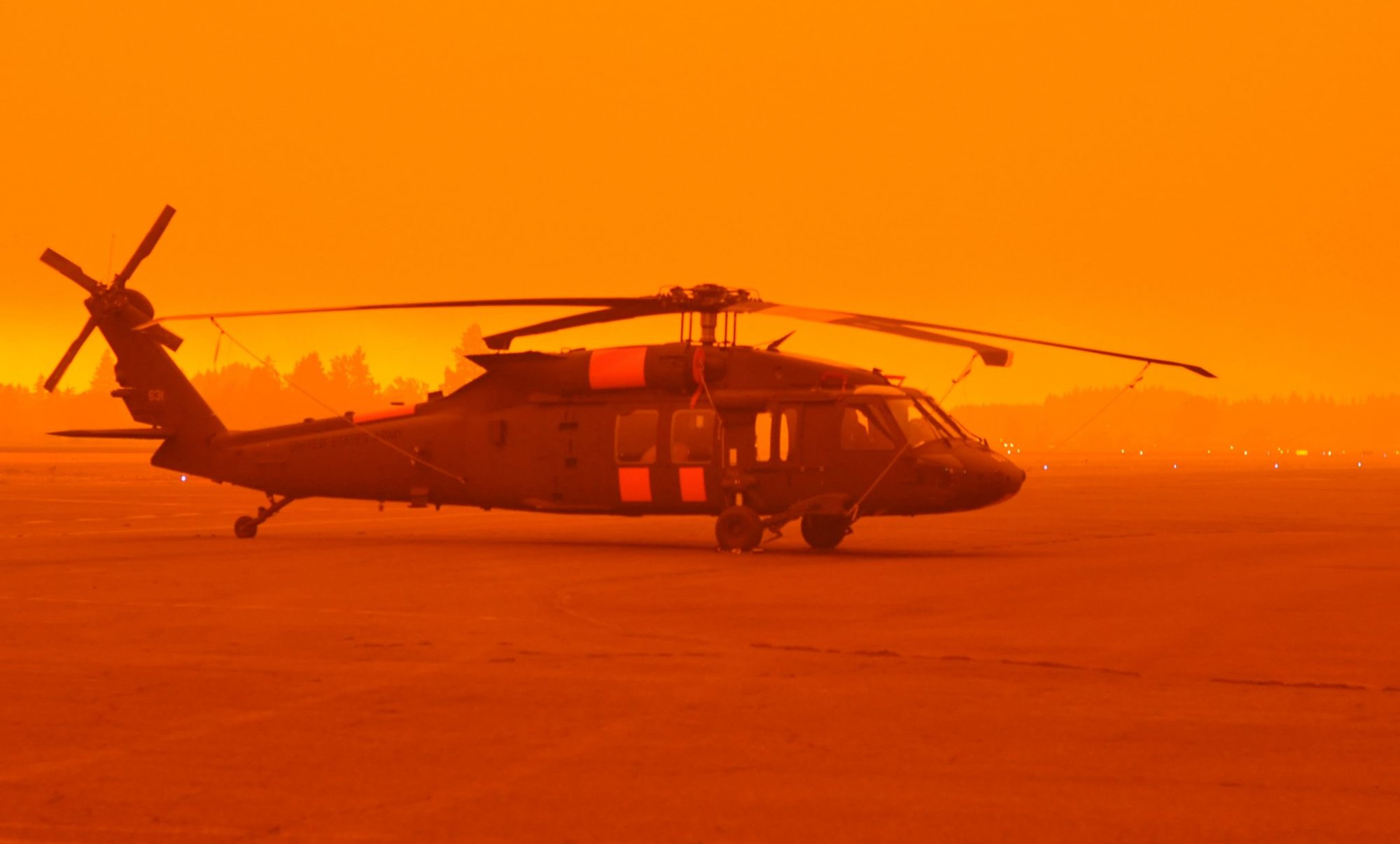 An Army National Guard UH-60M Black Hawk  helicopter waits on the tarmac in heavy smoke at the Aurora State Airport, near Aurora, Ore. on September 9, 2020. Flight crews from the Oregon Army National Guard’s Gulf Company, 1st Battalion, 189th Aviation Regiment based out of Salem, Ore. were called in to support state and local officials as unprecedented fire conditions forced evacuations across the state. Guard helicopters have dropped more than 22,000 gallons of water on Oregon’s wildland fires since mid-August. (National Guard photo by Maj. Leslie Reed, Oregon Military Department Public Affairs).
