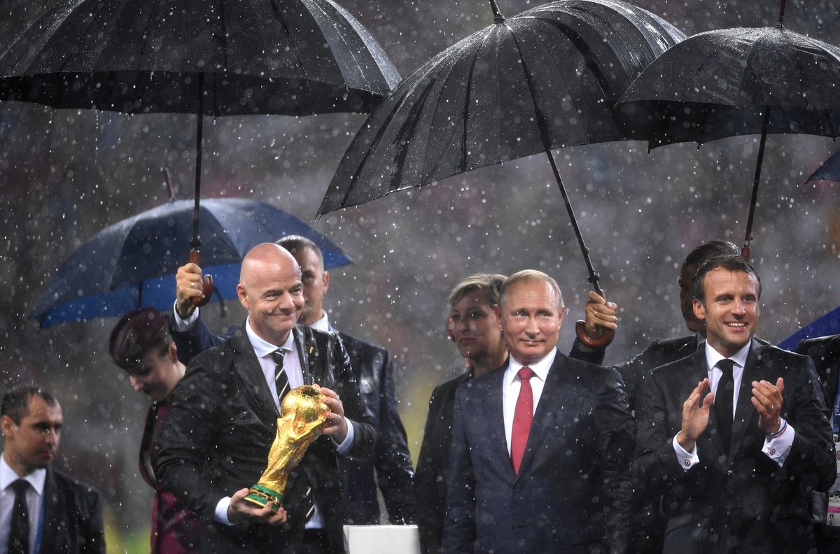 FIFA president Gianni Infantino carries the World Cup trophy in front of President of Russia Vladimir Putin and French President Emmanuel Macron following the 2018 FIFA World Cup Final between France and Croatia at Luzhniki Stadium on July 15, 2018 in Moscow, Russia.  Photo by Laurence Griffiths/Getty Images