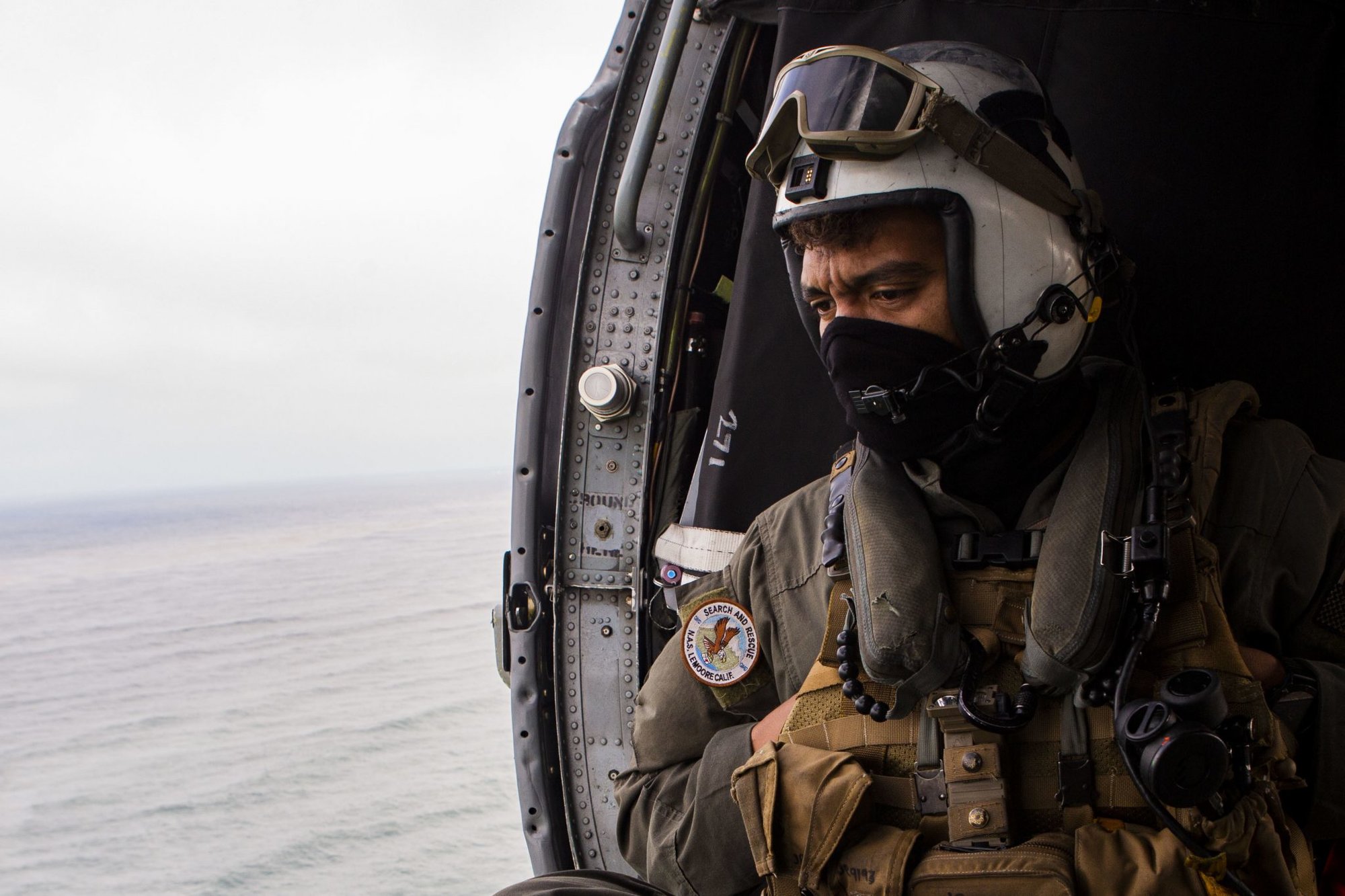 Naval Air Crewman 2nd Class Joseph Rivera, a search and rescue swimmer assigned to the amphibious assault ship USS Makin Island (LHD-8), looks out of a U.S. Navy MH-60 Seahawk while conducting search and rescue operations following an AAV-P7/A1 assault amphibious vehicle mishap off the coast of Southern California, July 30, 2020. Marine Corps photo by Lance Cpl. Mackenzie Binion