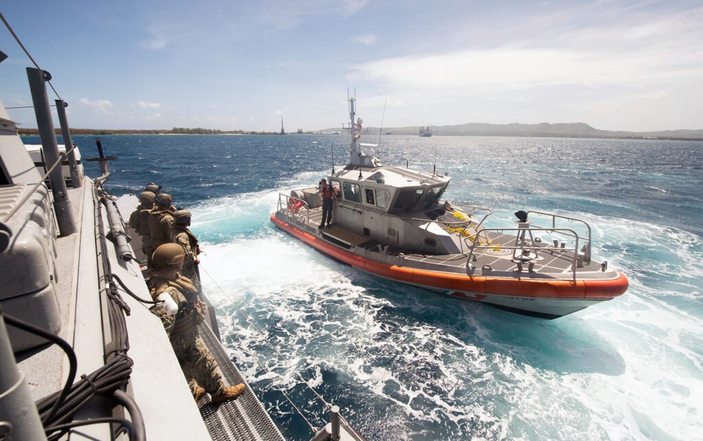A 47-foot Motor Lifeboat, assigned to U.S. Coast Guard Sector Guam, pulls alongside a Mark VI patrol boat, assigned to Coastal Riverine Group (CRG) 1, Det. Guam, during a towing exercise in Apra Harbor, Guam, March 28, 2018. Photo by Mass Communication Specialist 1st Class Stacy D. Laseter/U.S. Navy Combat Camera.