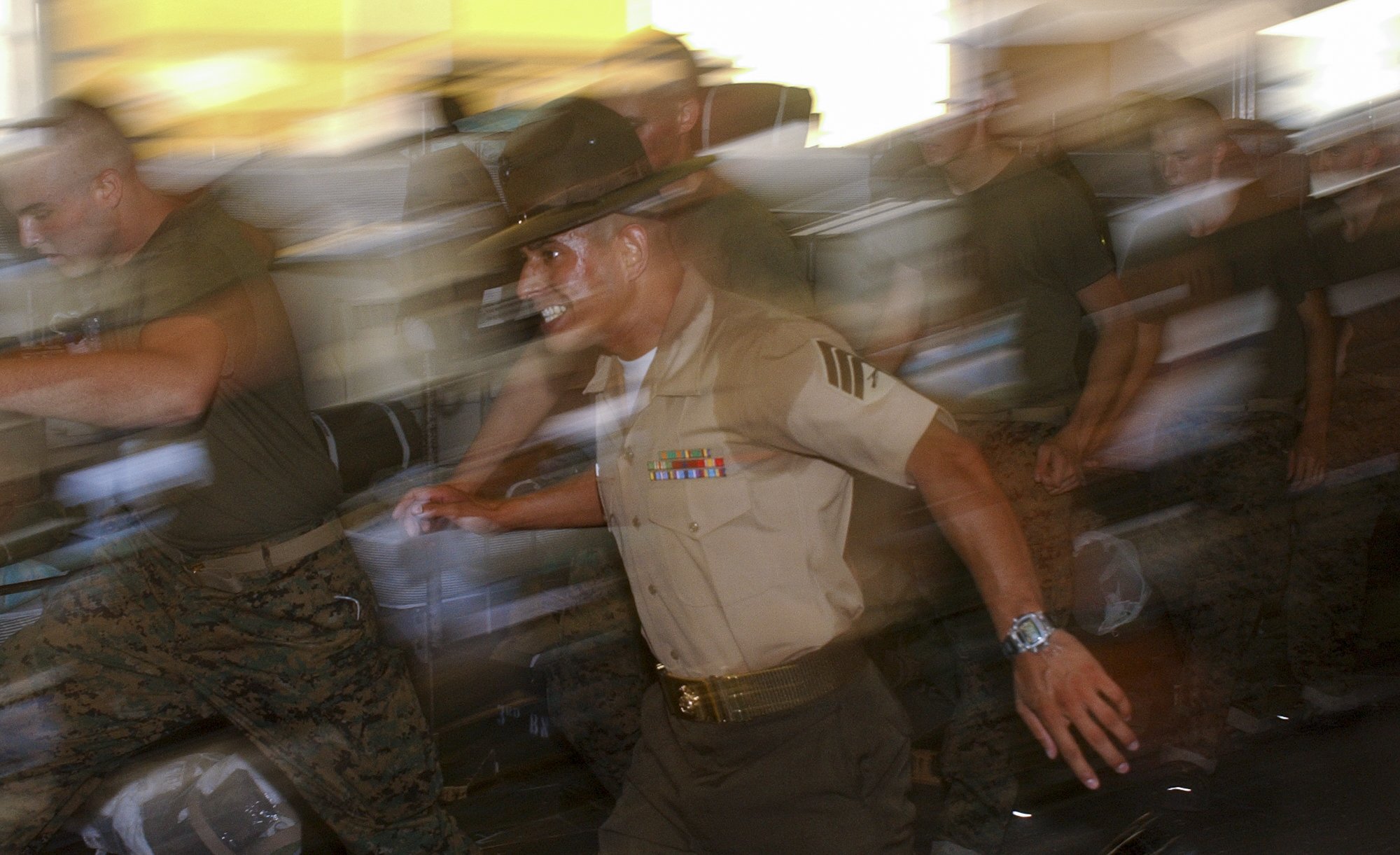 Sgt. Fernando Galvan, drill instructor, Platoon 3013, Lima Company, 3rd Recruit Training Battalion, sprints past recruits as they hustle back to get on line in the squad bay July 11, 2003. Photo by Ethan E. Rocke.