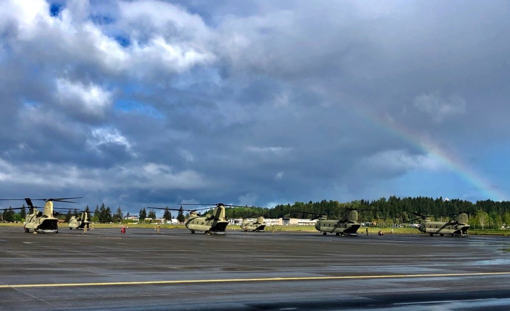 After a rainy morning a rainbow appears over the CH-47 Chinook helicopters during Bravo Company, 1st Battalion, 168th General Support Aviation deployment ceremony at the Washington Army National Guard Army Aviation Support Facility at Joint Base Lewis-McChord, Wash. on May 6, 2020. Bravo Company is set to deploy to the middle east for the third time in 10 years. Photo by Sara Morris, courtesy of the U.S. Army.