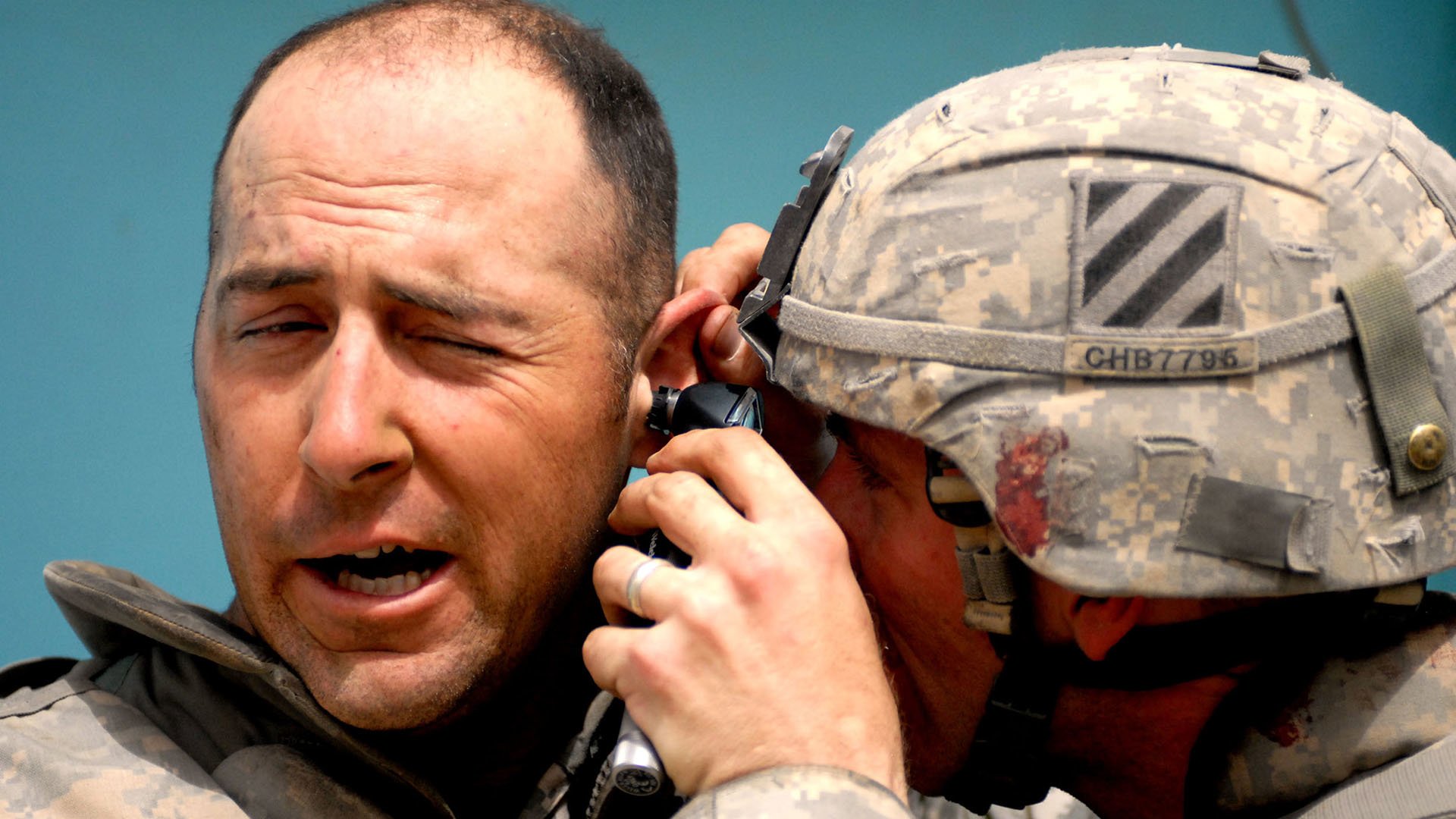 A medic examines a soldier's ear following an explosion at Joint Security Station Sadr City in the Thawra 1 neighborhood of Baghdad. US Army photo by Sgt. Zach Mott.