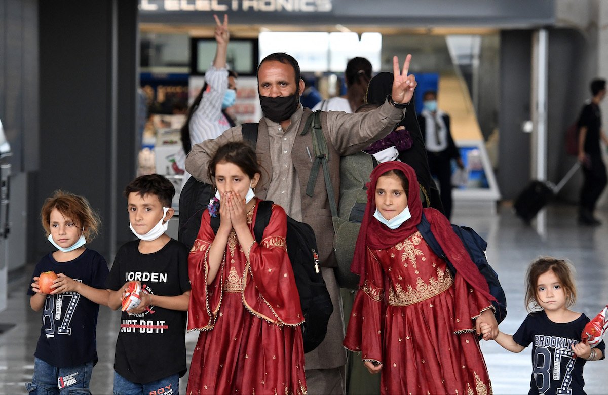 Afghan refugees arrive at Dulles International Airport on August 27, 2021, in Dulles, Virginia, after being evacuated from Kabul following the Taliban takeover of Afghanistan. Photo by Olivier Douliery/AFP via Getty Images.