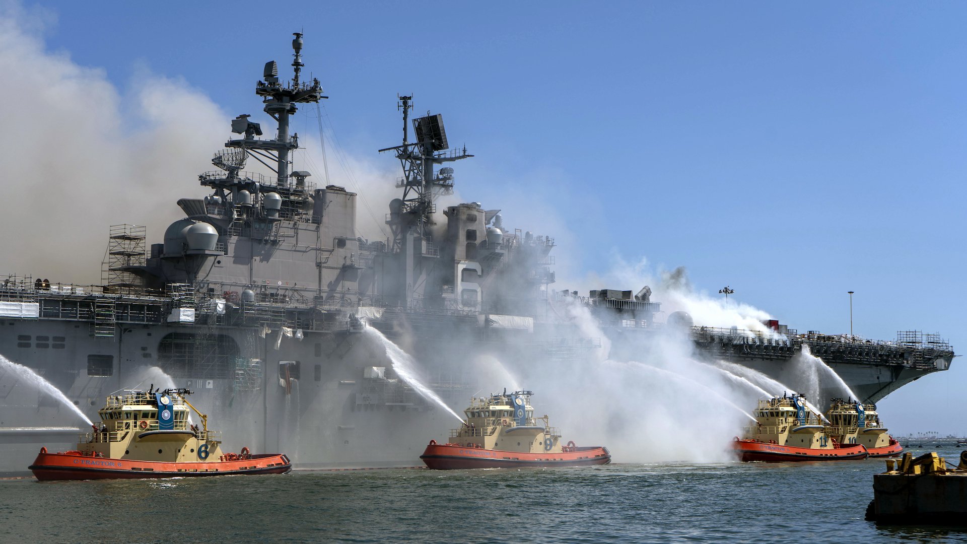 Sailors and federal firefighters combat a fire on board the USS Bonhomme Richard at Naval Base San Diego, July 12, 2020. Navy photo by Mass Communication Specialist 3rd Class Christina Ross.