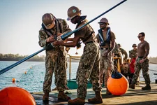 Navy Seaman Qwante Huggins, right, and Navy Petty Officer 3rd Class Joshua Banks, both assigned to Amphibious Construction Battalion 1, work to affix the buoy connector aboard the commercial Australian vessel Bandicoot during Exercise Talisman Sabre 23 in Weipa, Australia, Friday, July 21, 2023. Department of Defense photo.
