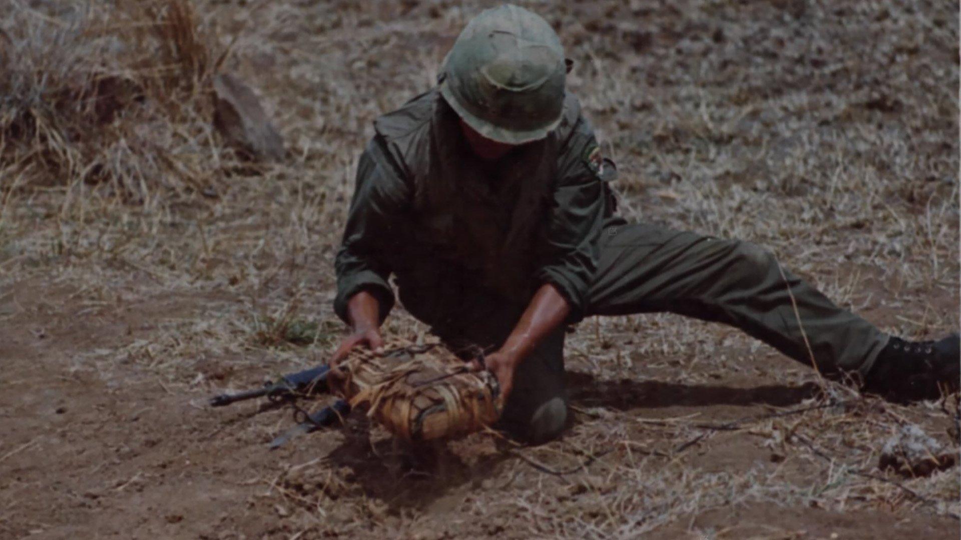 A soldier of the 26th Regiment, ROK Tiger Division, lifts a Viet Cong booby-trap from the ground during a demonstration near HQ, Song Cau, 2 September 1969. Wikimedia Commons photo.