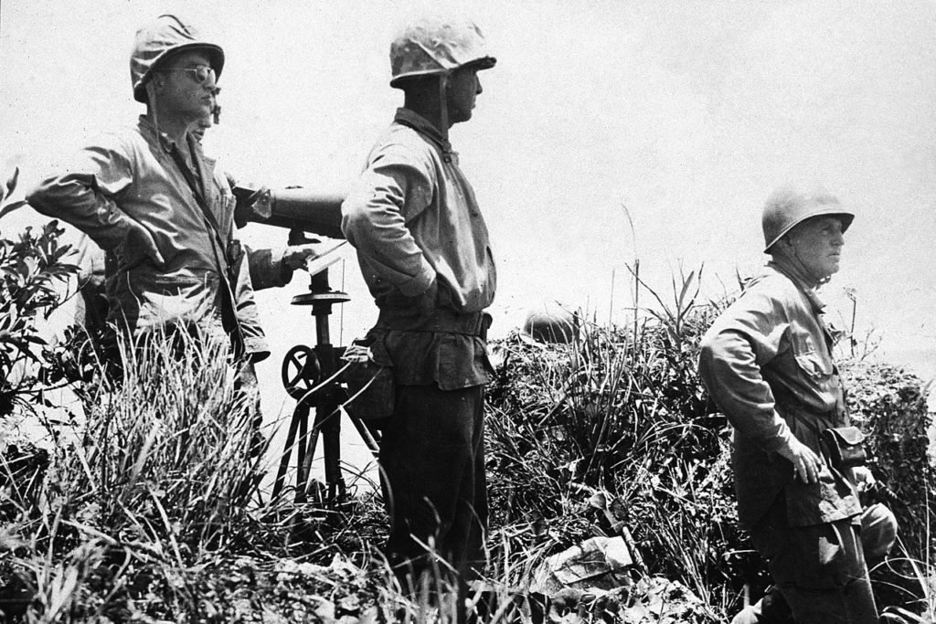 This is the last photograph taken of Army Lt. Gen. Simon B. Buckner Jr., (right), just before he was killed later that day, June 18, 1945. He was observing the battle action when he was killed by artillery fire at this location. The other two staff officers in the photo were not seriously hurt. Photo courtesy of the National Archives.