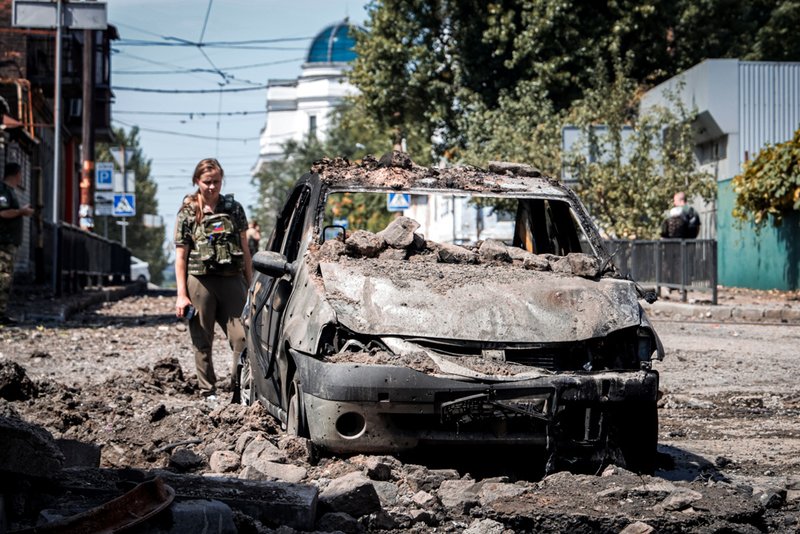 An investigator looks at a destroyed car.