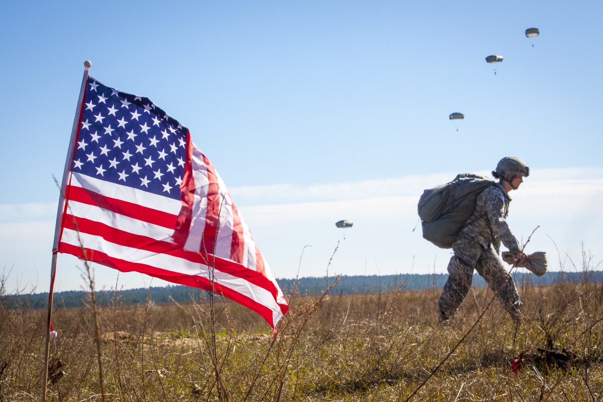 A female paratrooper assigned to the 82nd Airborne Division returns after completing her jump in participation for the 18th Annual Randy Oler Memorial Operation Toy Drop, hosted by U.S. Army Civil Affairs & Psychological Operations Command (Airborne), Dec. 4, 2015, on Sicily Drop Zone at Fort Bragg, N.C. Operation Toy Drop is the world’s largest combined airborne operation and collective training exercise with seven partner-nation paratroopers participating and allows Soldiers the opportunity to help children in need receive toys for the holidays. (U.S. Army photo by Sgt. Destiny Mann, 450th Civil Affairs BN Airborne)