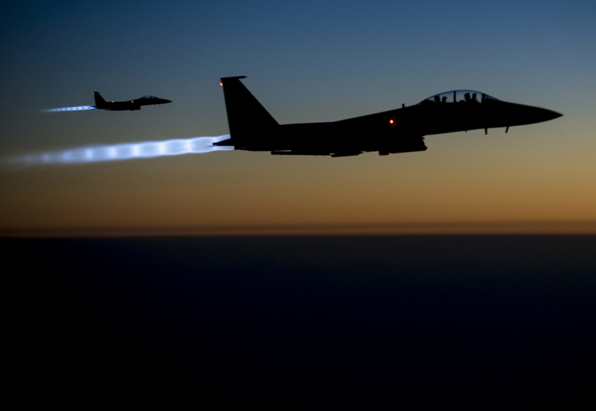 A pair of U.S. Air Force F-15E Strike Eagles fly over northern Iraq early in the morning of Sept. 23, 2014, after conducting airstrikes in Syria. These aircraft were part of a large coalition strike package that was the first to strike ISIL targets in Syria. (U.S. Air Force photo by Senior Airman Matthew Bruch/Released)