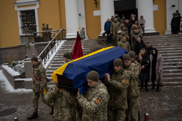 Soldiers carry the coffin of Eduard Strauss, a Ukrainian serviceman who died in combat on Jan. 17 in Bakhmut, during a farewell ceremony in Kyiv, Ukraine, Monday, Feb. 6, 2023. AP photo by Daniel Cole.