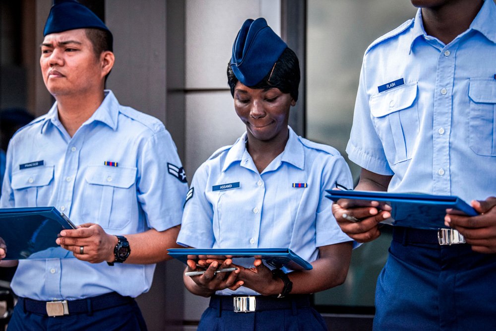 Airman 1st Class Joshua Fancisco, from the Philippines, left, Airman 1st Class D'elbrah Assamoi, from Cote D'Ivoire, center, and Airman 1st Class Jordan Flash, from Jamaica, looks at their U.S. Certificate of Citizenship.