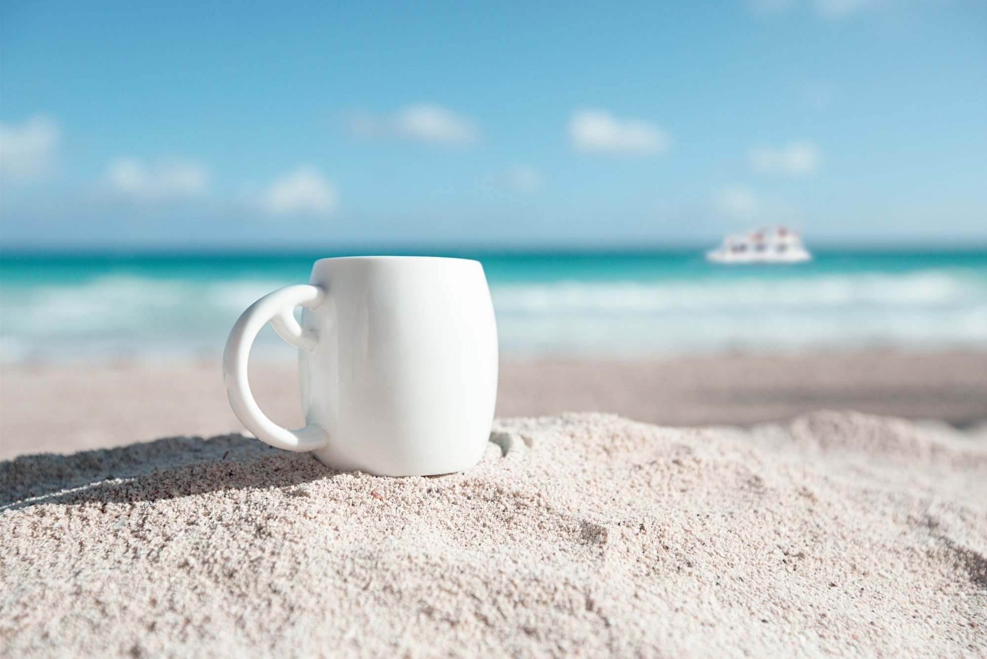 white espresso coffee cup with ocean , beach and seascape. Shallow dof.