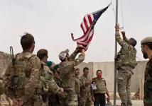 A US flag is lowered as American and Afghan soldiers attend a handover ceremony from the US Army to the Afghan National Army, at Camp Antonik, in Helmand province May 2, 2021. Afghan Ministry of Defense photo/public domain.