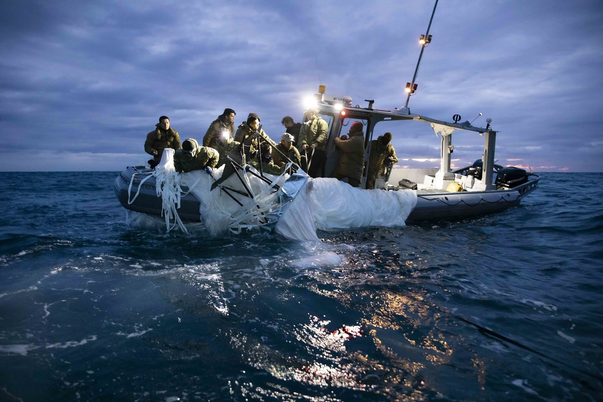 This image provided by the U.S. Navy shows sailors assigned to Explosive Ordnance Disposal Group 2 recovering a high-altitude surveillance balloon off the coast of Myrtle Beach, S.C., Feb. 5, 2023. (U.S. Navy via AP)