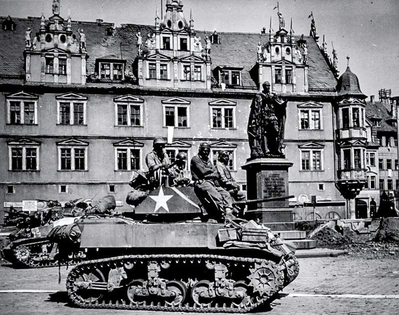 Tank crews from the 761st Tank Battalion await orders to clean out scattered Nazi machine gun nests.