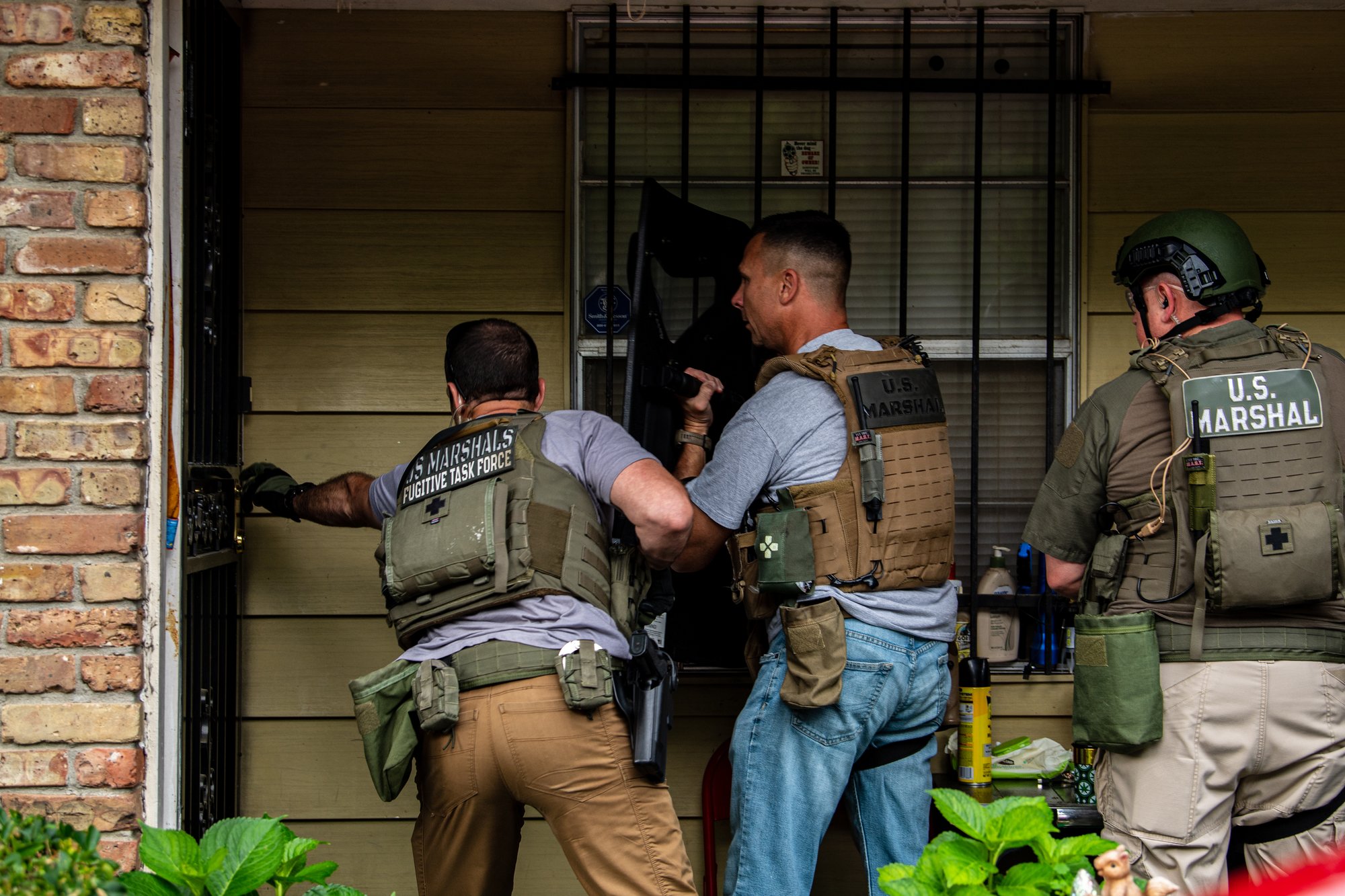 Members of the US Marshals Fugitive Task Force the moment they attempt to breach a house to serve an arrest warrant in the Memphis area on June 7, 2022. US Marshals Service photo.