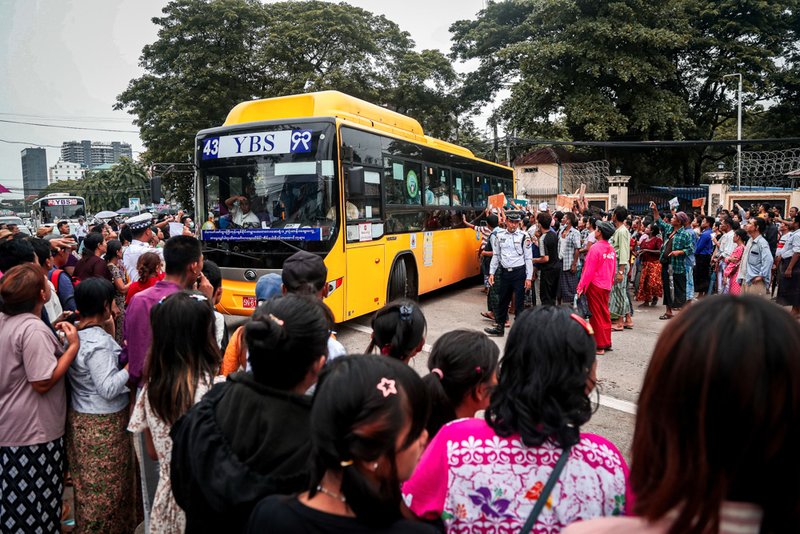 A bus carrying released prisoners is welcomed by family members and colleagues as it leaves Insein Prison.