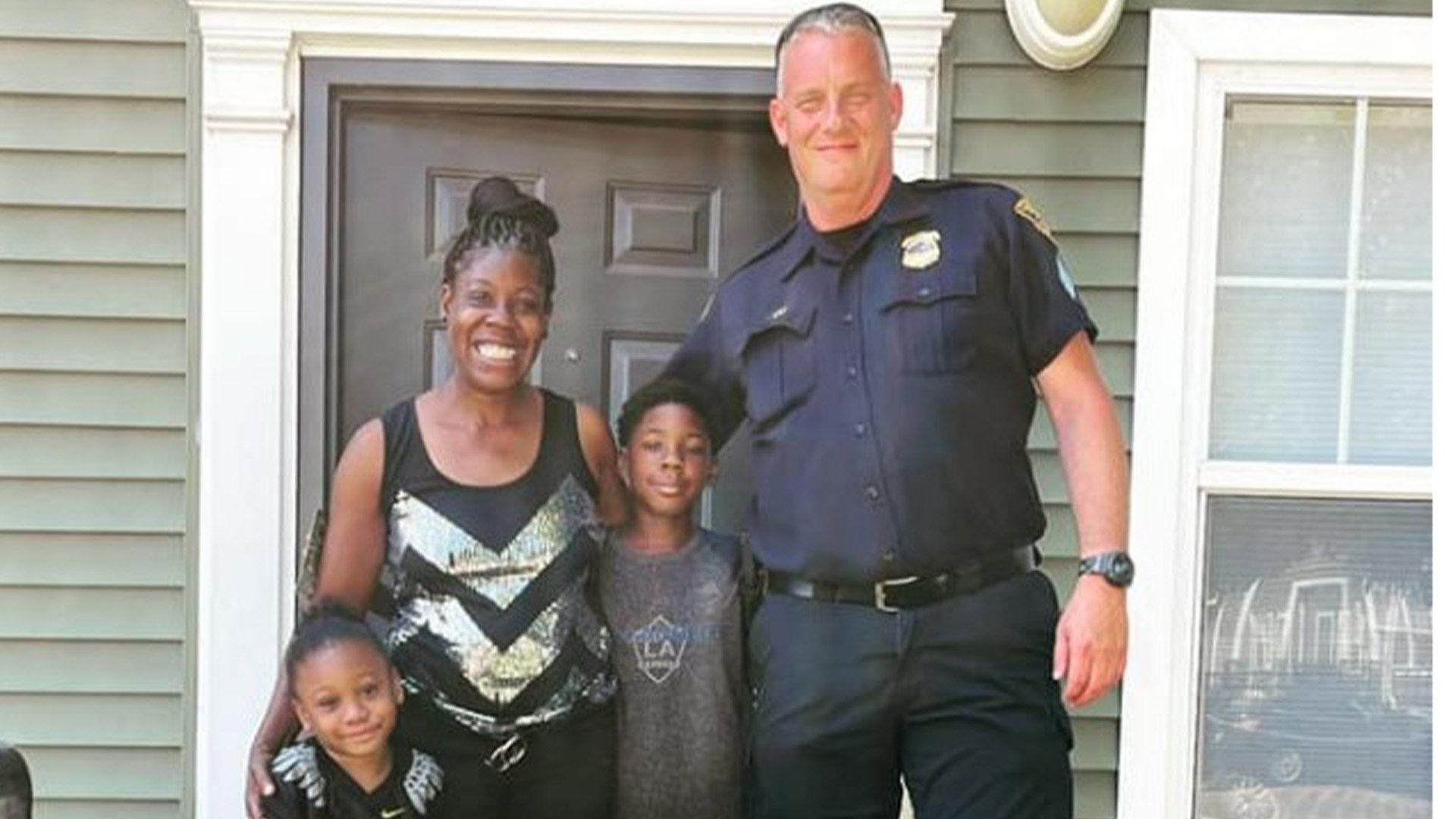 Cleveland Police Sgt. Raymond “Ray” O’Connor poses with Tomika Johnson and her family. The quick-thinking Johnson helped save the officer's life during a community celebration in the Ohio city on Aug. 20, 2022. Cleveland Police Department photo.