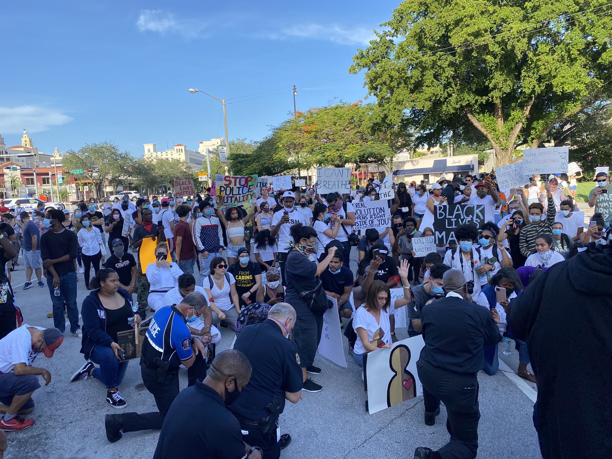 Demonstrators and police chiefs from Miami Dade County kneel and say a prayer. Photo courtesy of Twitter/Franklin White.