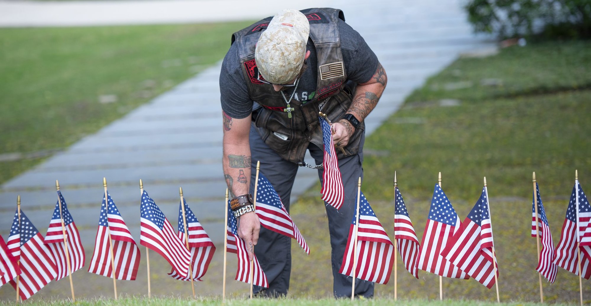 U.S. Army veteran Aaron Murphy places American flags around Clemson University’s Scroll of Honor for upcoming Memorial Day ceremonies, May 24, 2018. Volunteers placed 491 flags around the memorial – one for every Clemson graduate who has given the ultimate sacrifice. (Photo by Ken Scar)