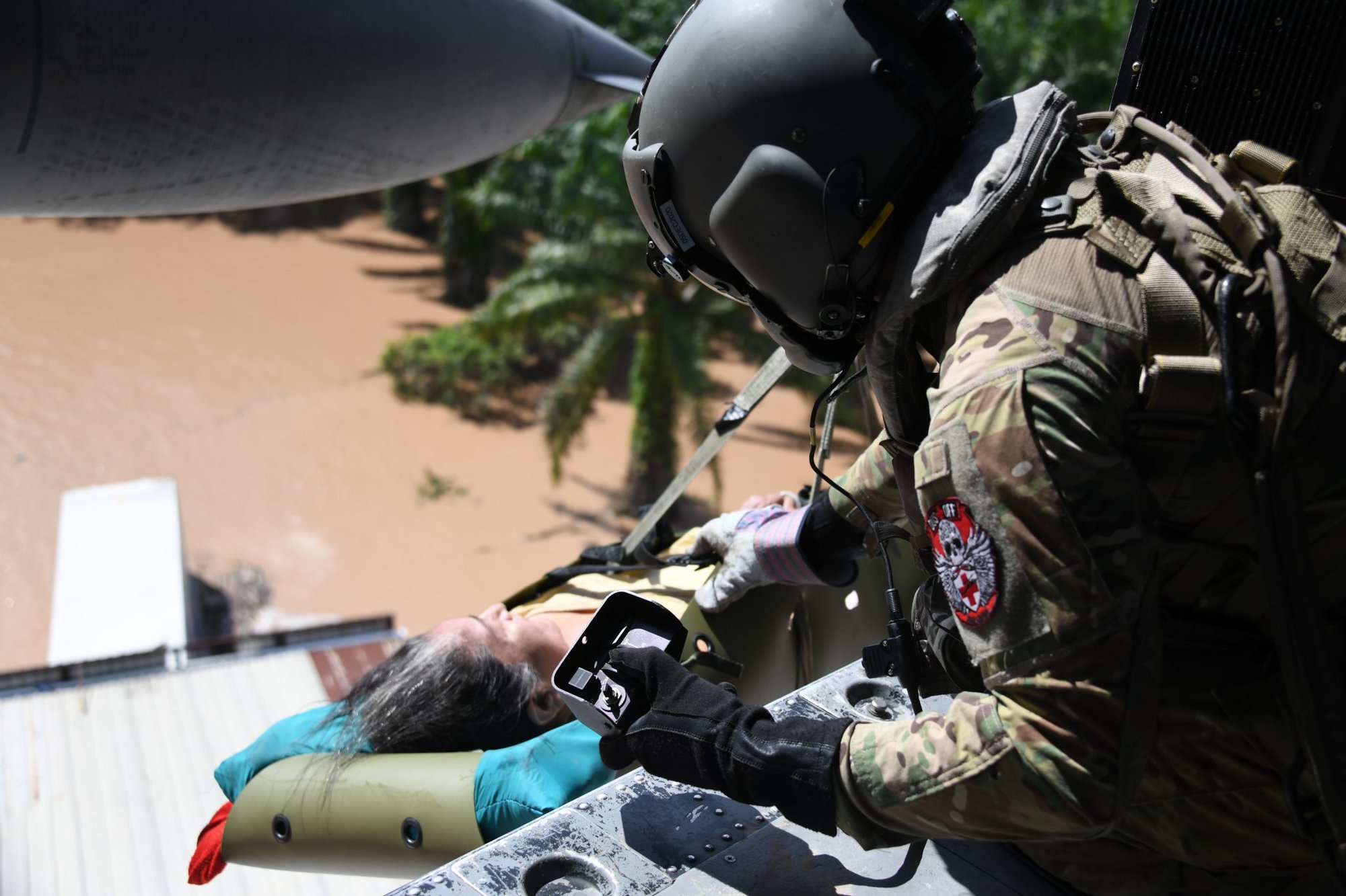 A U.S. Army HH-60 Black Hawk helicopter crew member assigned to the 1-228th Aviation Regiment, Joint Task Force-Bravo hoists a Honduran woman in a gurney above the floodwaters of Hurricane Eta at San Pedro Sula, Honduras, Nov. 7, 2020. JTF-Bravo’s 1-228th Aviation Regiment provided aviation support while also conducting medical evacuation operations to rescue stranded survivors. (U.S. Air Force photo by Staff Sgt. Elijaih Tiggs)