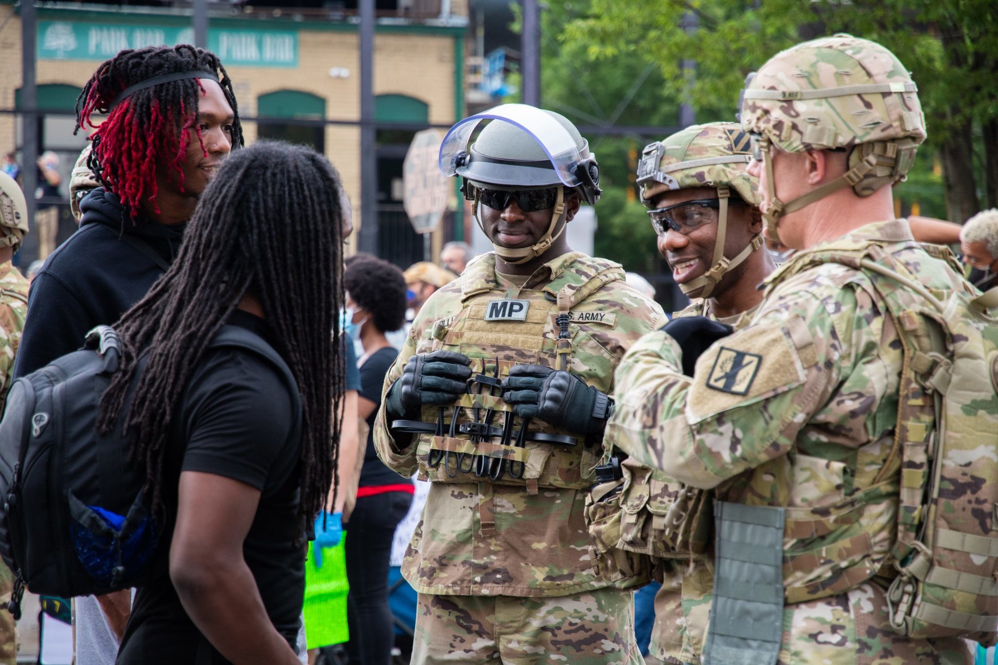 U.S. Soldiers with the Georgia National Guard share a lighthearted moment with citizens attending a peaceful protest near Centennial Olympic Park in Atlanta, Georgia, June 5, 2020. Georgia National Guardsmen are assisting law enforcement agencies to protect property, prevent destruction of infrastructure, and ensure the safety of Georgia citizens. (U.S. Air National Guard photo by Senior Master Sgt. Roger Parsons)