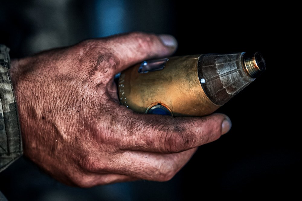 A Ukrainian soldier holds a projectile fuse of self-propelled howitzer.