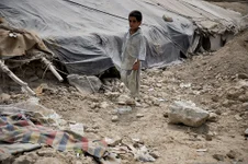 An Afghan boy walks in front of one of the many makeshift homes at a refugee camp in Kabul, Afghanistan. Afghans seeking to flee more than 40 years of war in Afghanistan can count Pakistan out as a destination. US Air Force photo by Senior Airman Christopher Hatch, courtesy of Wikimedia Commons/public domain.