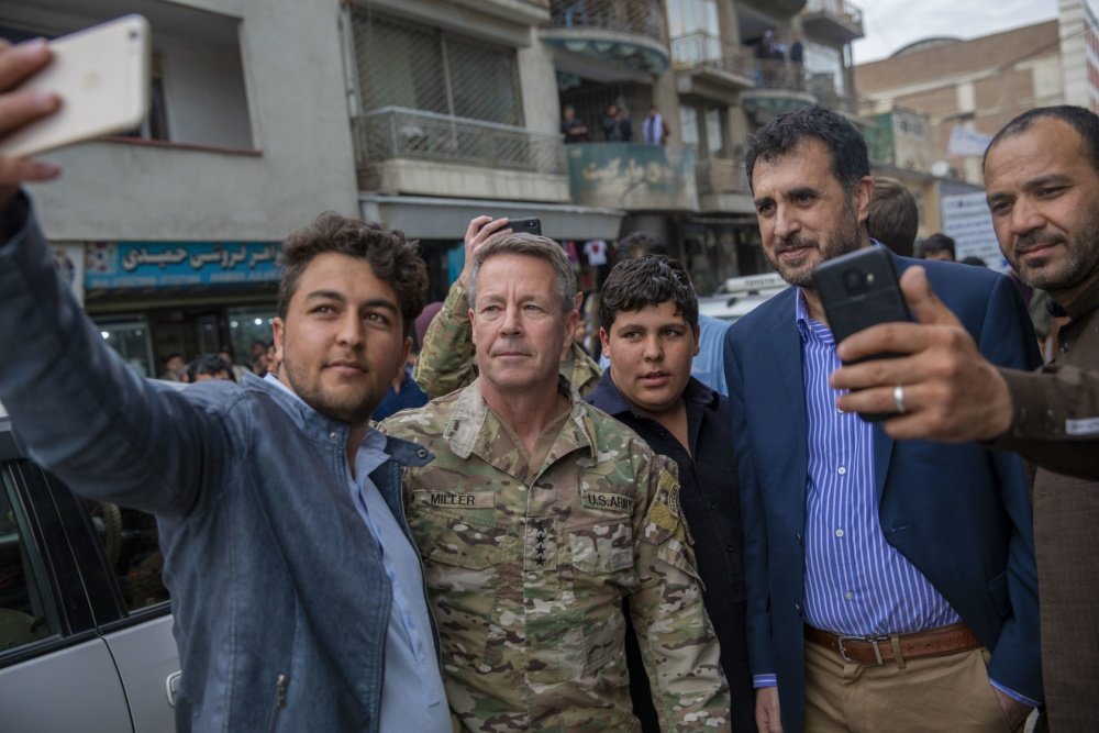 Resolute Support Commander US Army Gen. Austin Scott Miller and Afghan Minister of Defense Asadullah Khalid take selfies with residents in downtown Kabul, Afghanistan, Feb. 26, 2020, during the seven-day reduction in violence that preceded the signing of the US-Taliban Peace Agreement in Kabul. US Army Reserve photo by Spc. Jeffery J. Harris, courtesy of DVIDS.
