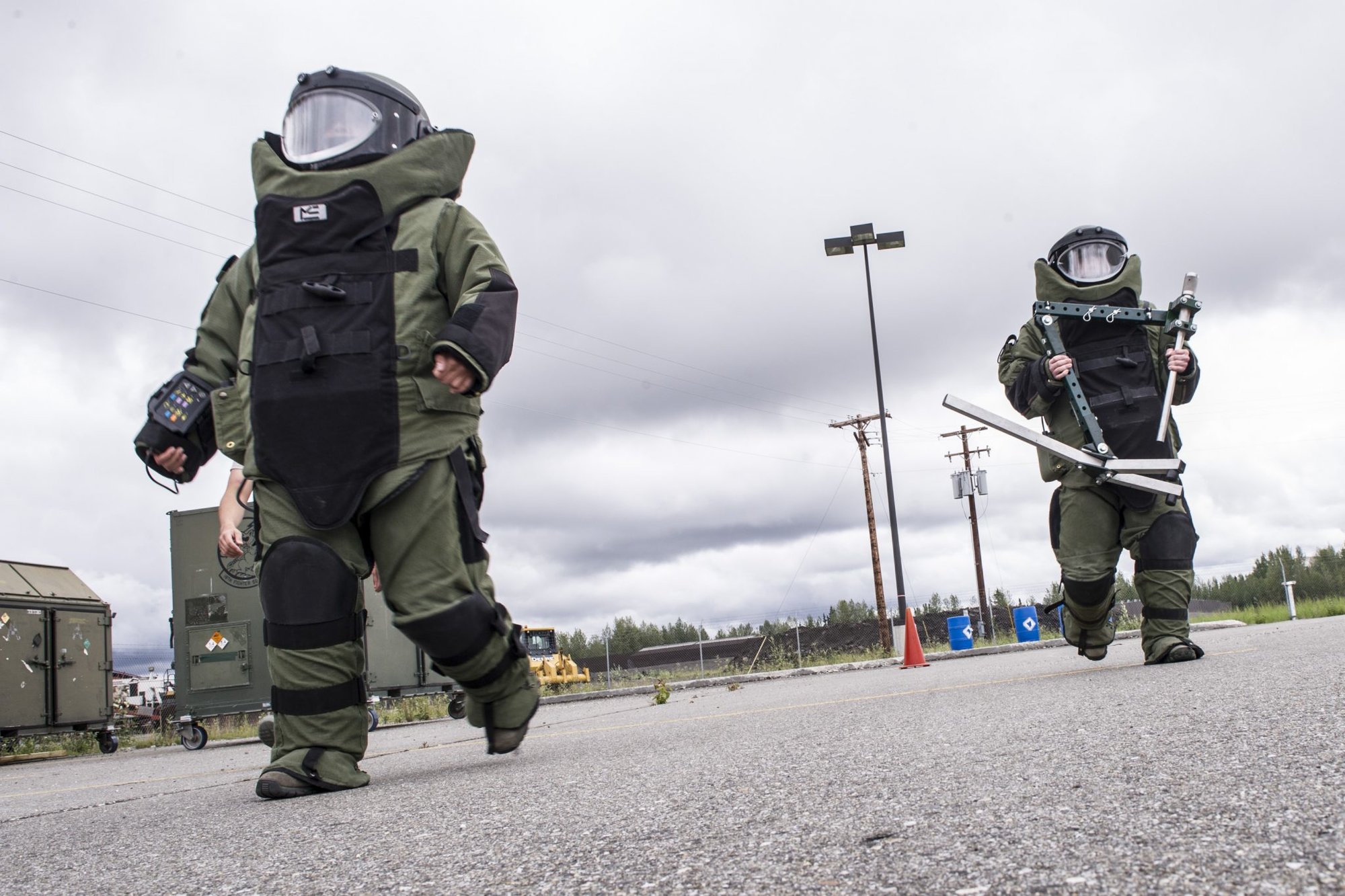 U.S. Air Force Airmen 1st Class Alex Westing and Devin Paulino, both with the 354th Comptroller Squadron, race through an obstacle course during an explosive ordnance disposal work center tour July 25, 2014, Eielson Air Force Base, Alaska. The Airmen put on an 80-pound EOD 9 bomb suit, raced back and forth in a parking lot and attempted to locate inert improvised explosive devices in and around a Humvee. (U.S. Air Force photo by Senior Airman Joshua Turner/Released)