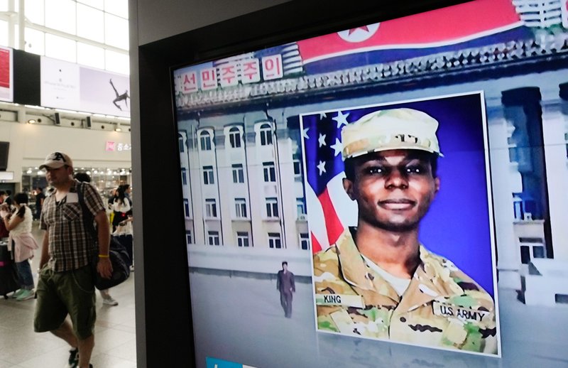 A TV screen shows a file image of American soldier Travis King.