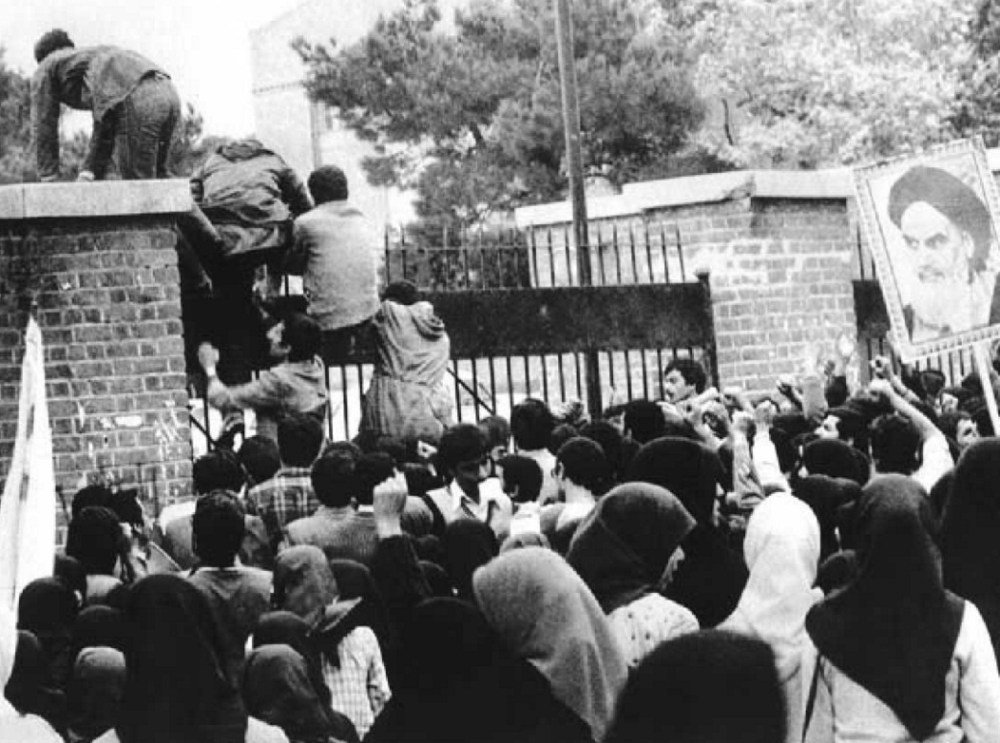Student protestors climb over the gate to the U.S. Embassy in Tehran on November 4, 1979.
