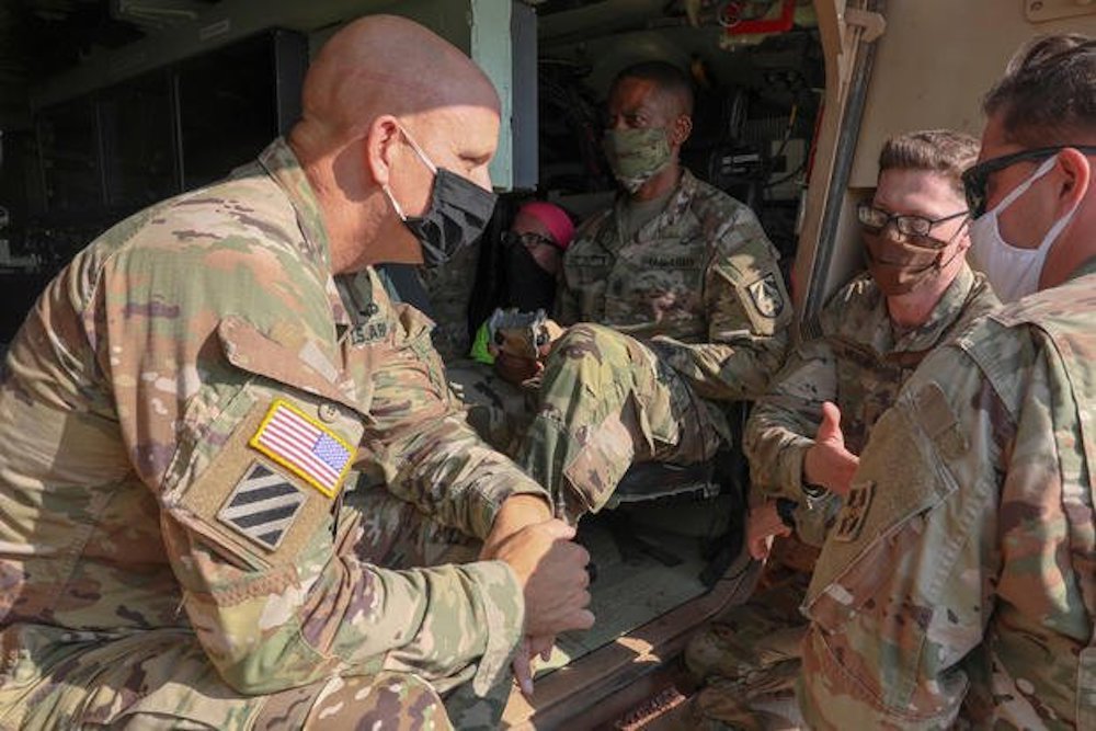 Then-Brig. Gen. Richard Coffman (left), director of the next generation combat vehicle cross-functional team, engages with Sgt. Matthew Morris (middle right) and Spc. Gage Payne (right), both of 4-10 Cav, as U.S. Army Futures Command Command Sgt. Maj. Michael Crosby (middle left) drives a Robotic Combat Vehicle from inside a Mission Enabling Technologies – Demonstrator at a Fort Carson, Colorado training area on August 5, 2020. Photo by Liane Hatch/U.S. Army.