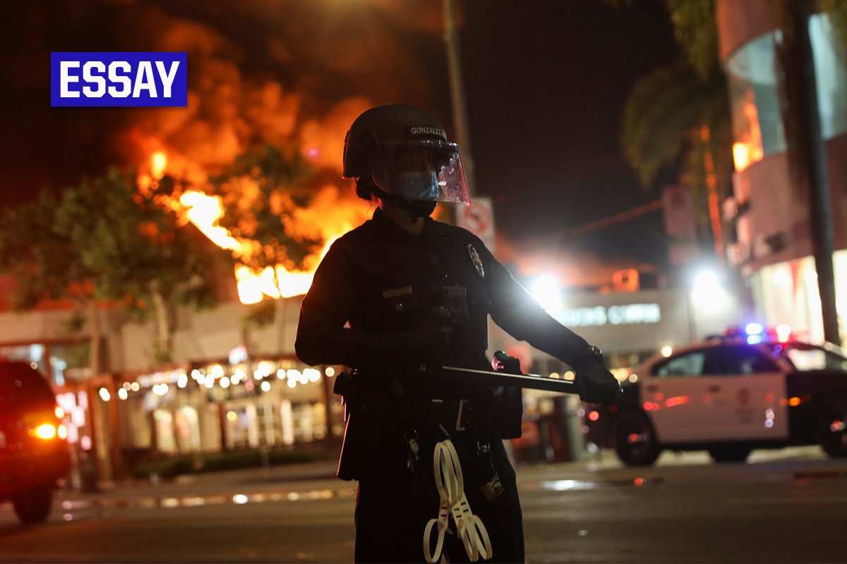 A law enforcement officer takes position as a building burns during nationwide unrest following the death in Minneapolis police custody of George Floyd, in Los Angeles, California, U.S., May 30, 2020. REUTERS/Patrick T. Fallon - Stock.Adobe.com