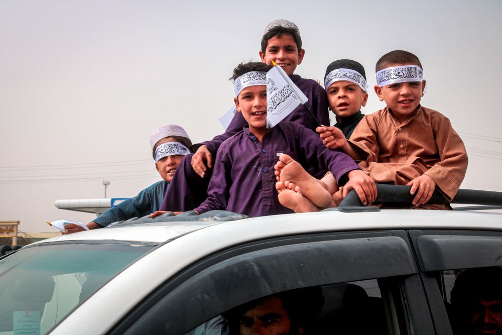Children hold Taliban flags during a celebration.